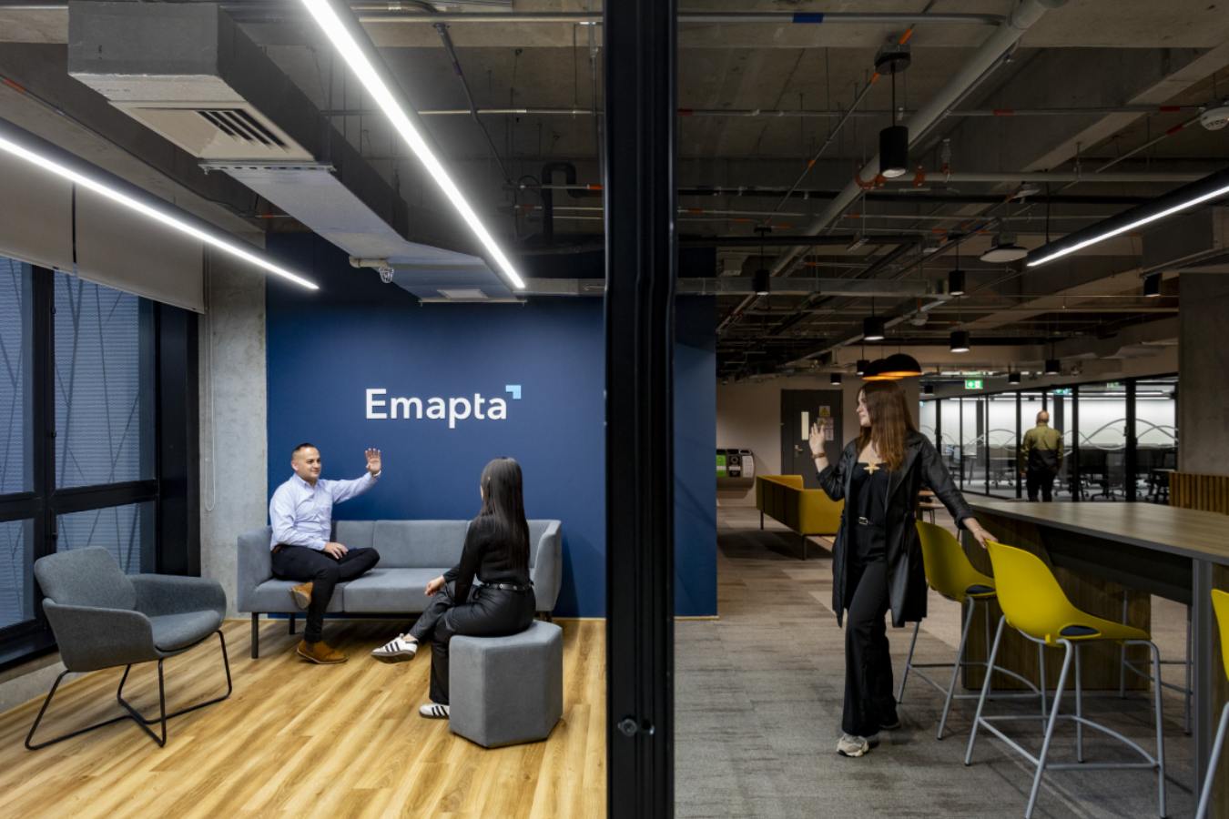 Emapta Offices - Casual meeting zone with blue branding and exposed industrial ceiling - Contract Workplaces.jpg